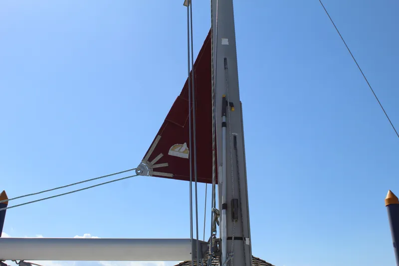 Slide: The Image of Dufour Gib Sea 37 sailboat mast and sail, 2003 model, against a clear blue sky. - 12