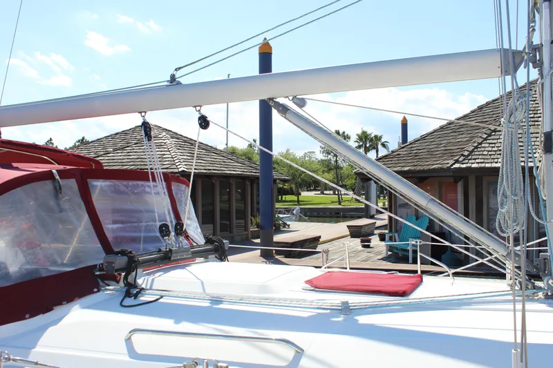 Slide: The Image of 2003 Dufour Gib Sea 37 sailboat docked at a marina with wooden huts. - 10
