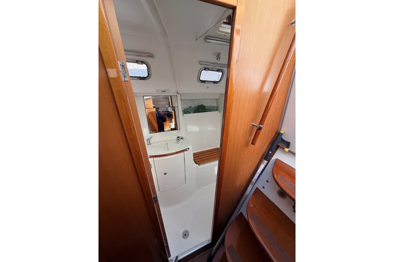 Slide: The Image of Interior of 2006 Beneteau Oceanis 343 sailboat, featuring a compact bathroom with wooden accents. - 19