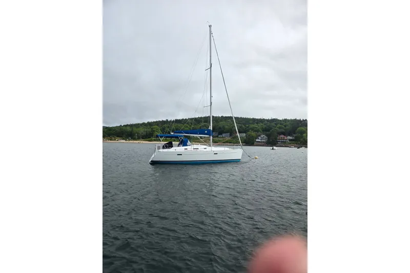 The Image of Sailboat on water: 2006 Beneteau Oceanis 343, anchored near a forested shoreline. - 1