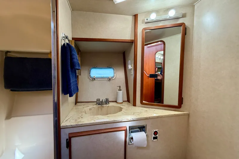 Slide: The Image of 1985 Chris-Craft 382 Commander bathroom with sink, mirror, and porthole window. - 40