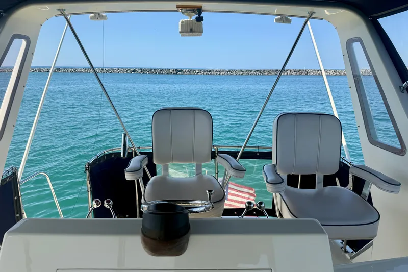 Slide: The Image of Interior view of 1985 Chris-Craft 382 Commander yacht with two seats overlooking the ocean. - 62