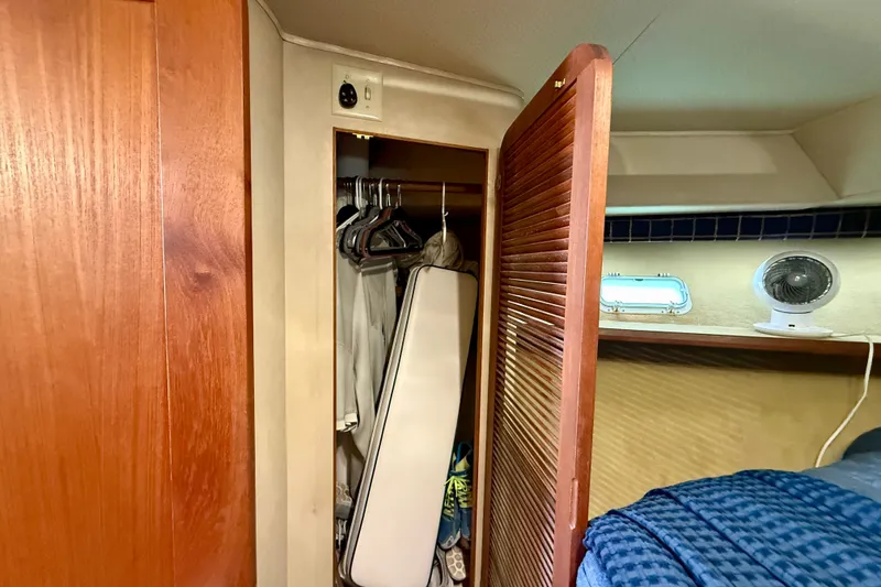 Slide: The Image of 1985 Chris-Craft 382 Commander cabin closet with wooden door and fan on shelf. - 33