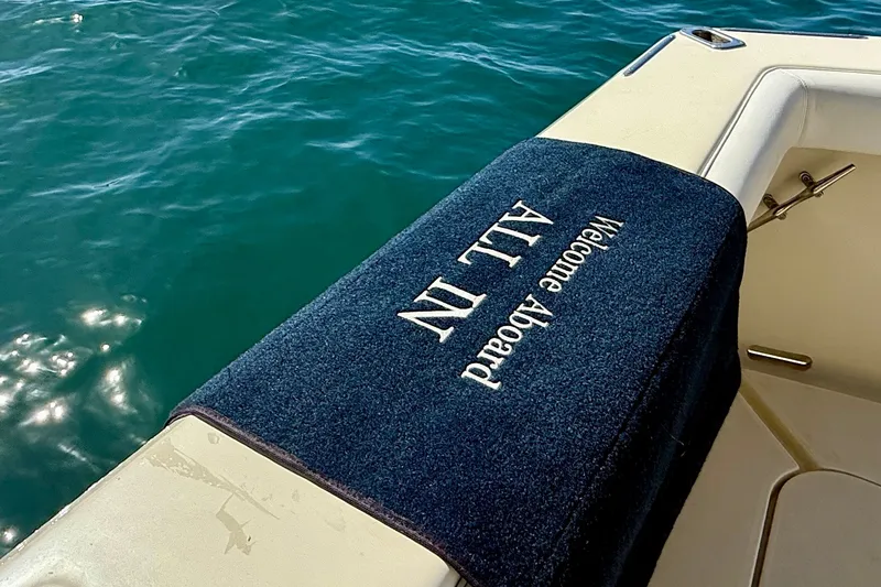 Slide: The Image of Chris-Craft 382 Commander 1985 boat with "Welcome Aboard" mat on deck by water. - 54