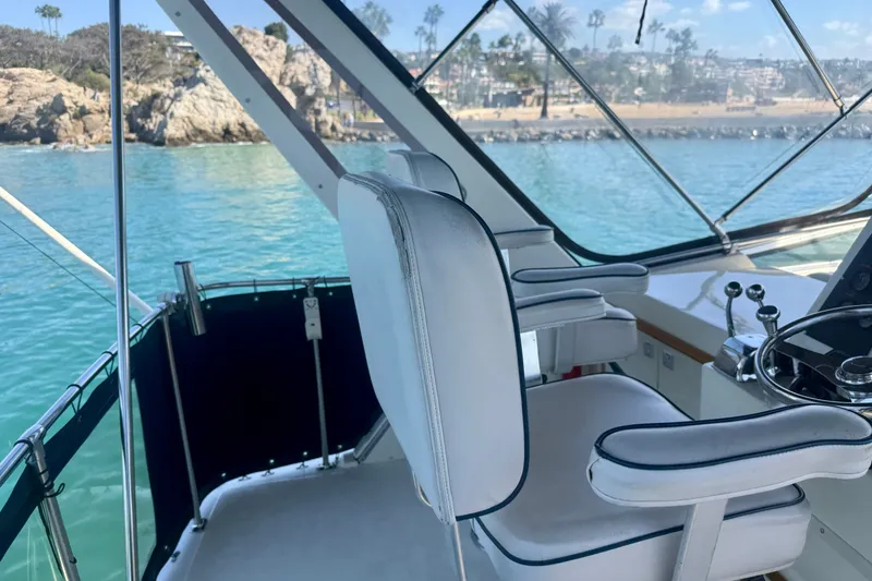Slide: The Image of 1985 Chris-Craft 382 Commander helm with ocean view, featuring white captain's chair and steering wheel. - 60
