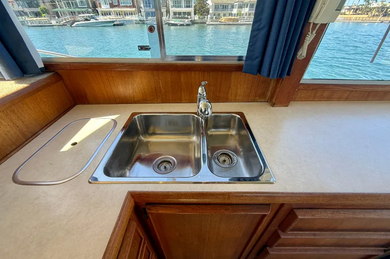 Slide: The Image of 1985 Chris-Craft 382 Commander kitchen sink with waterfront view through window. - 26