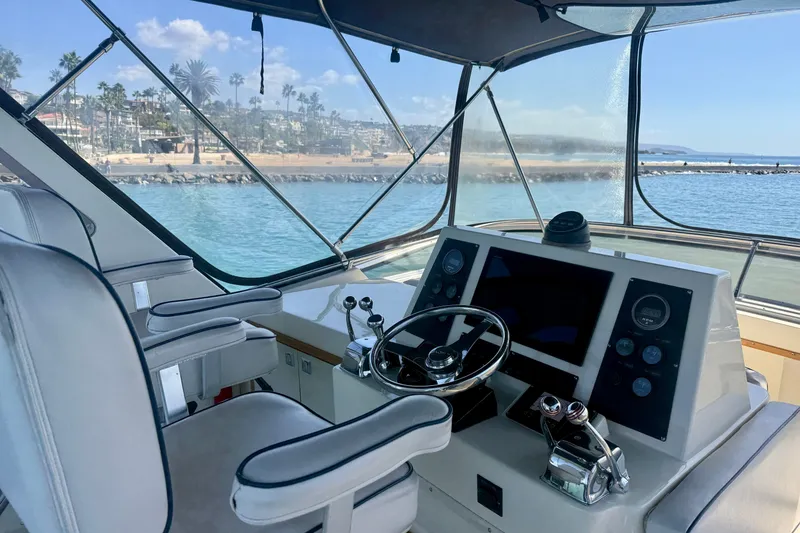 Slide: The Image of Helm of 1985 Chris-Craft 382 Commander yacht with scenic coastal view. - 59