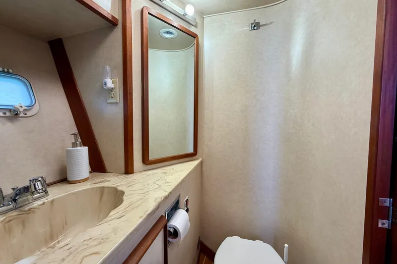 Slide: The Image of 1985 Chris-Craft 382 Commander bathroom with sink, mirror, and toilet. - 39
