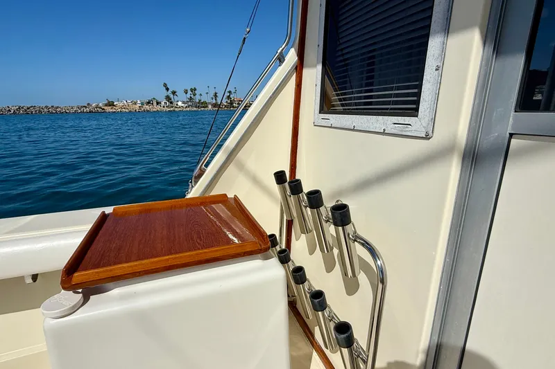 Slide: The Image of 1985 Chris-Craft 382 Commander boat deck with rod holders and wooden tray, ocean view. - 52