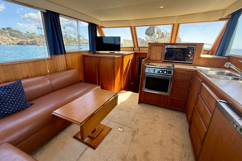 Slide: The Image of Interior of 1985 Chris-Craft 382 Commander yacht with kitchen and seating area. - 13