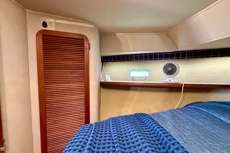 Slide: The Image of 1985 Chris-Craft 382 Commander cabin interior with wooden closet and cozy bedding. - 31