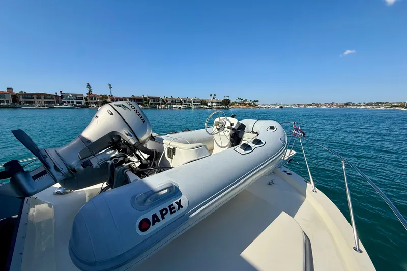 Slide: The Image of 1985 Chris-Craft 382 Commander with Apex inflatable boat on deck, overlooking coastal waters. - 74
