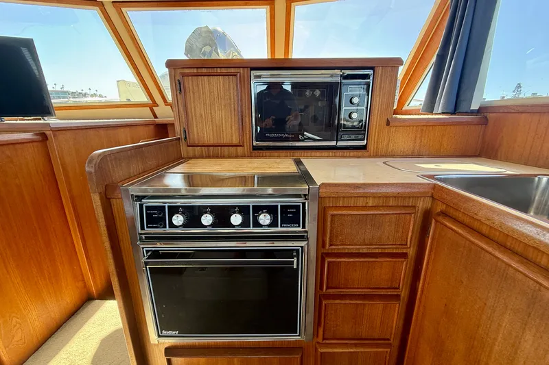 Slide: The Image of 1985 Chris-Craft 382 Commander yacht kitchen with wood cabinetry and modern appliances. - 23