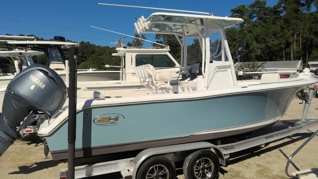 The Image of A 2023 Sea Hunt Ultra 229 boat on a trailer, featuring a Yamaha outboard motor. - 0