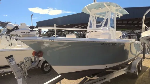 Slide: The Image of A 2023 Sea Hunt Ultra 229 boat on a trailer, featuring a Minn Kota motor and blue hull. - 1