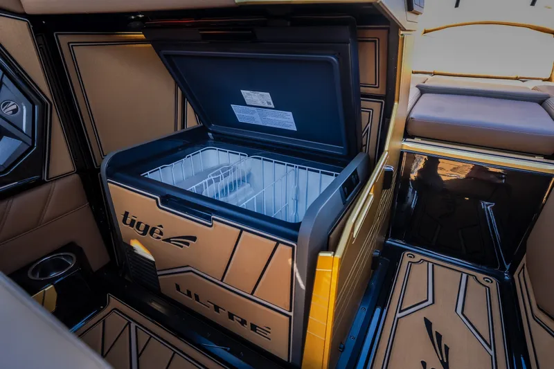 Slide: The Image of 2027 Tigé Ultré 25ZX boat interior with open built-in cooler. - 55