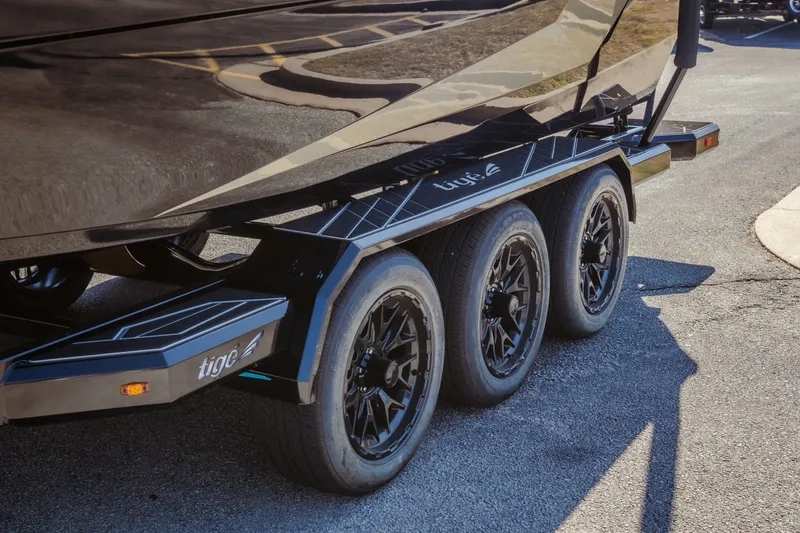 Slide: The Image of 2027 Tigé Ultré 25ZX boat trailer with triple axle and sleek black design. - 13