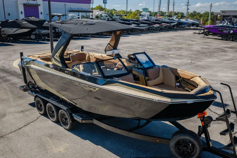 Slide: The Image of 2027 Tigé Ultré 25ZX boat on trailer in dealership lot, showcasing sleek design. - 7