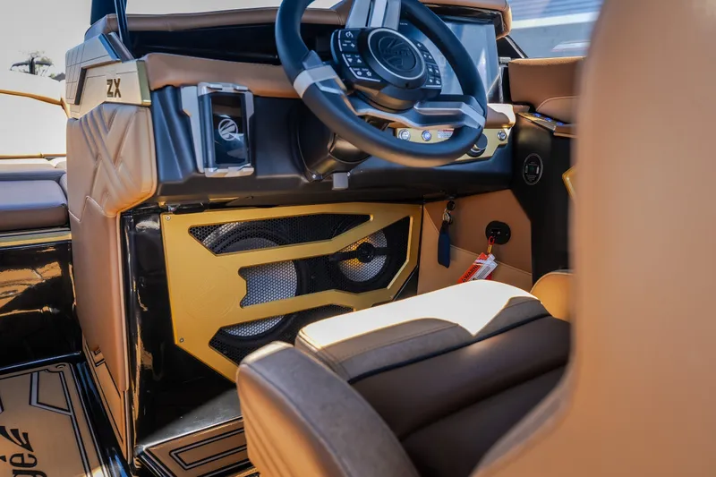 Slide: The Image of 2027 Tigé Ultré 25ZX boat interior with luxurious tan seating and advanced steering controls. - 47