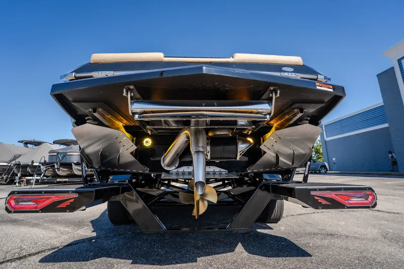 Slide: The Image of 2027 Tigé Ultré 25ZX boat rear view, showcasing propeller and exhaust system. - 26