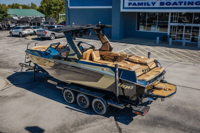 Slide: The Image of 2027 Tigé Ultré 25ZX boat on trailer at dealership, showcasing sleek design and luxury features. - 9