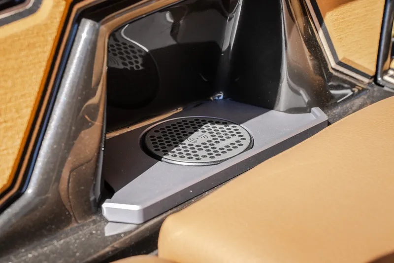 Slide: The Image of 2027 Tigé Ultré 25ZX boat interior with wireless charging pad and tan seating. - 40