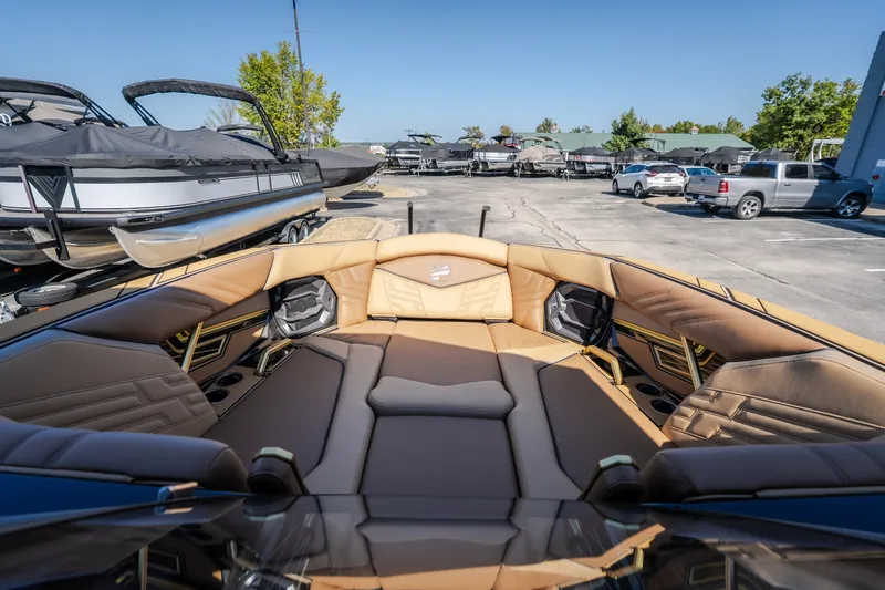 Slide: The Image of 2027 Tigé Ultré 25ZX boat interior with luxurious tan seating in a marina setting. - 56