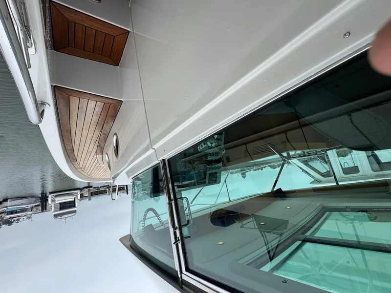 Slide: The Image of A sleek boat with wooden decks and large windows, docked on the water. - 17