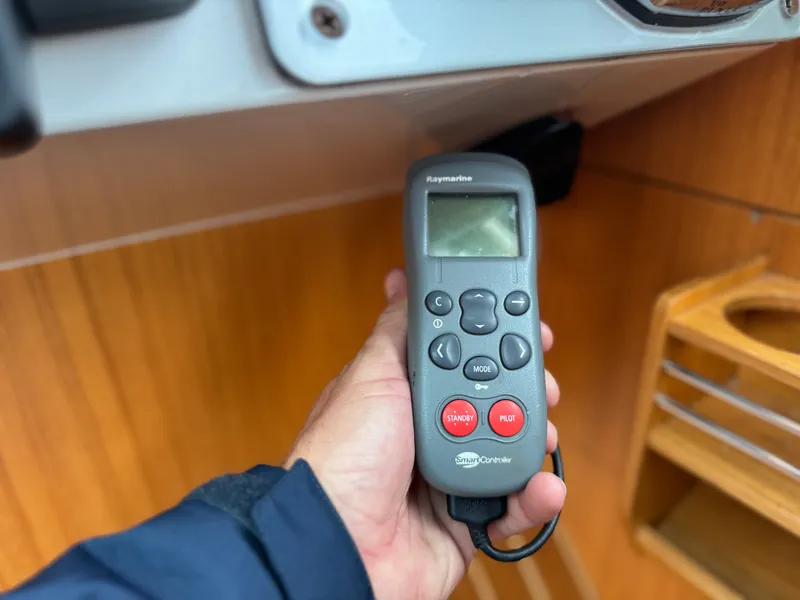 Slide: The Image of A hand holds a remote control with multiple buttons and a small screen. - 48
