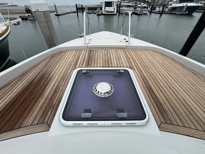 Slide: The Image of The image shows the foredeck of a 2013 Delta Powerboats 40 Walk Around with wood paneling. - 19