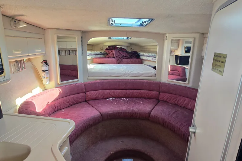 Slide: The Image of Interior of 1992 Sea Ray 380 Sun Sport with pink seating and cozy sleeping area. - 17