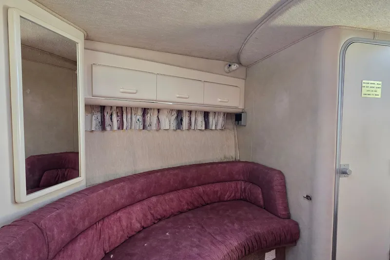 Slide: The Image of Interior of a 1992 Sea Ray 380 Sun Sport with maroon seating and storage cabinets. - 21