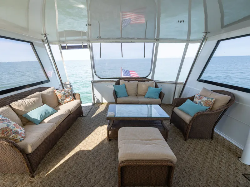 Slide: The Image of The image shows the interior of a 1995 Hatteras 52 Cockpit Motor Yacht with comfortable seating and a table. - 37