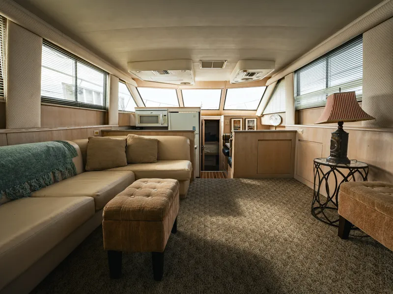 Slide: The Image of Interior of a 1995 Hatteras 52 Cockpit Motor Yacht with beige sofa and carpeted floor. - 42