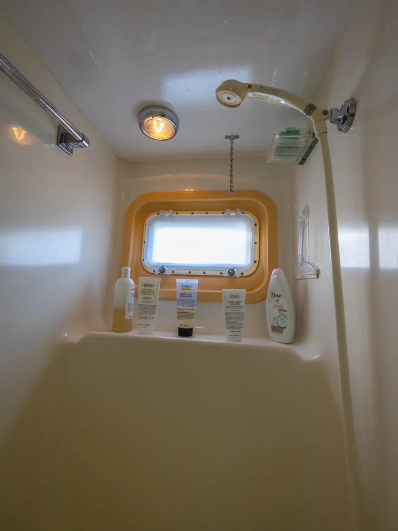 Slide: The Image of The yacht's shower features toiletries and a window with a yellow frame. - 49