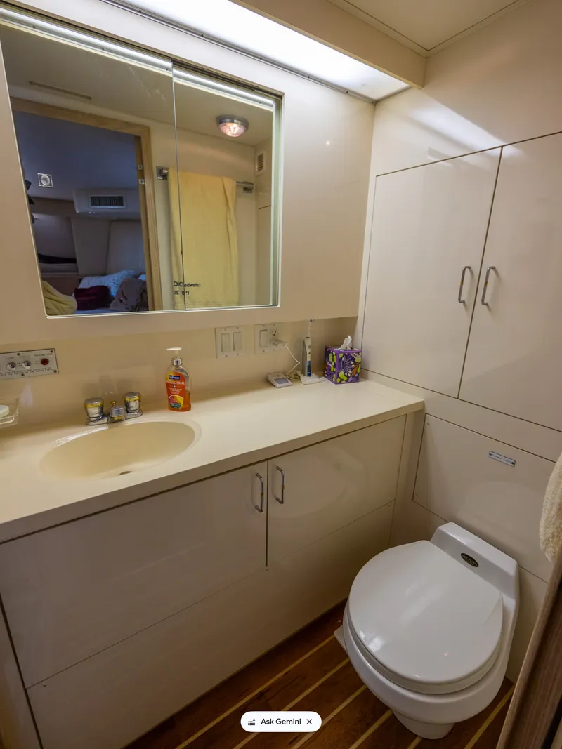 Slide: The Image of The bathroom of a 1995 Hatteras 52 Cockpit Motor Yacht with a sink, mirror, and toilet. - 46