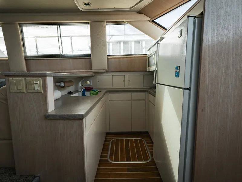 Slide: The Image of Interior of a 1995 Hatteras 52 Cockpit Motor Yacht featuring a kitchen and wood flooring. - 41