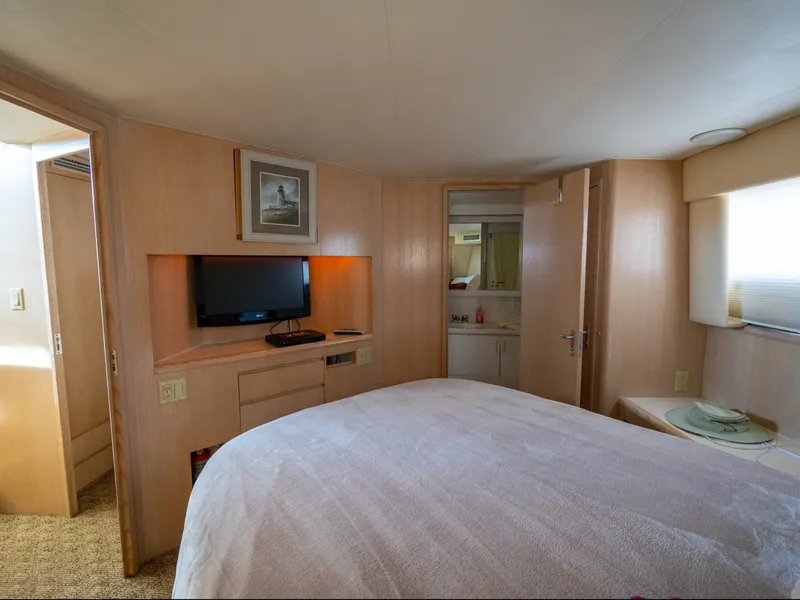 Slide: The Image of The image shows a cozy cabin with a large bed, a TV, and an adjoining bathroom. - 35
