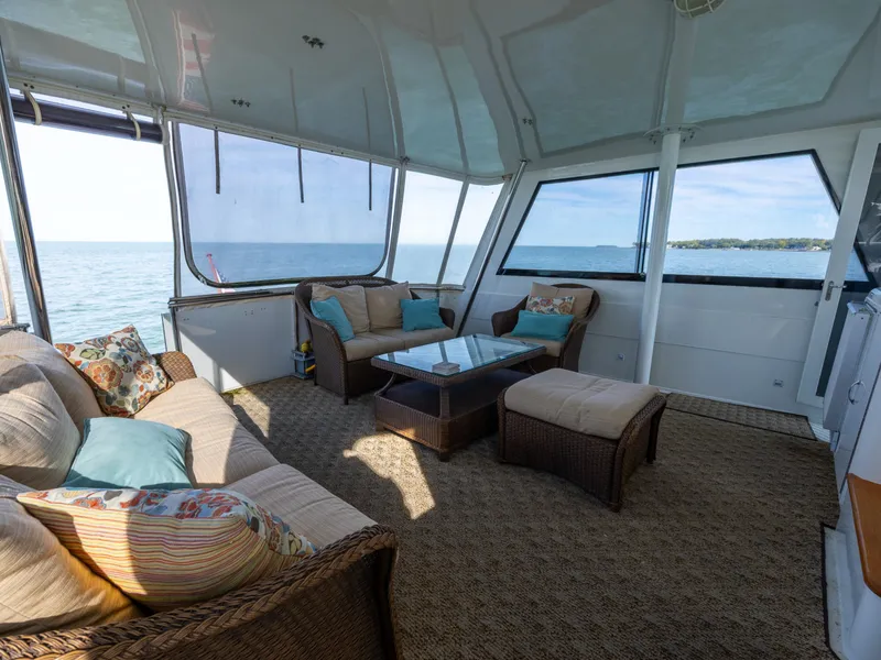 Slide: The Image of The image shows the interior of a 1995 Hatteras 52 Cockpit Motor Yacht with comfortable seating. - 38