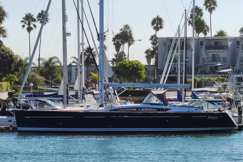 The Image of 2013 Jeanneau 57 yacht docked in a marina with palm trees in the background. - 1