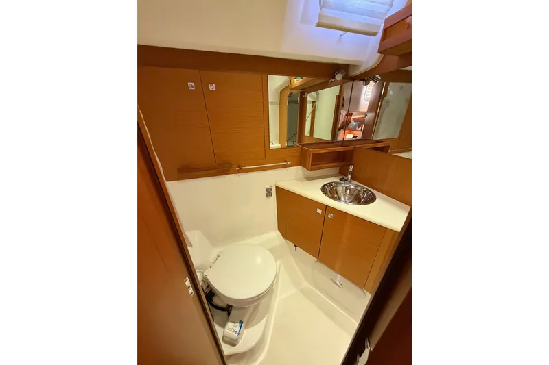 Slide: The Image of 2013 Jeanneau 57 yacht bathroom with wooden cabinetry and stainless steel sink. - 60