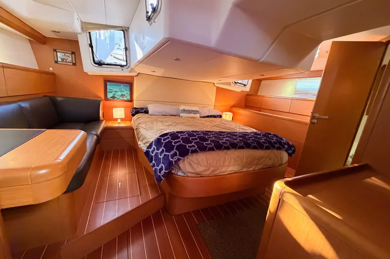 Slide: The Image of Luxurious interior of 2013 Jeanneau 57 yacht with cozy bed and elegant wood finish. - 57