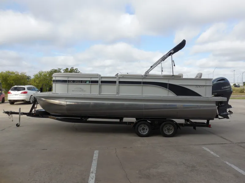 Slide: The Image of A 2019 Bennington 22 SSx APG pontoon boat on a trailer, parked in a lot. - 6