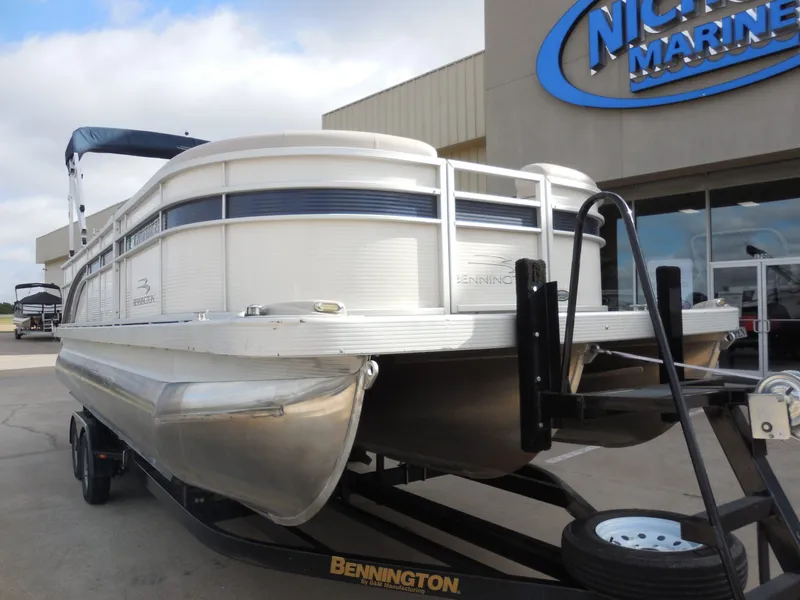 Slide: The Image of A 2019 Bennington 22 SSx APG pontoon boat on a trailer in front of a building. - 9