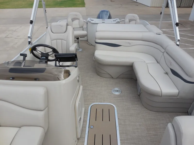 Slide: The Image of The image shows the interior of a 2019 Bennington 22 SSx APG pontoon boat with beige seating. - 15