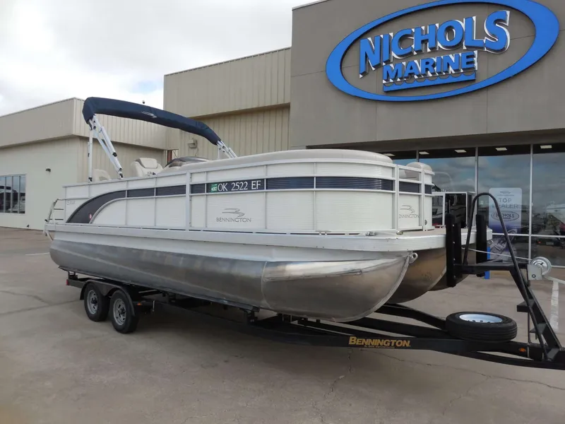The Image of A 2019 Bennington 22 SSx APG pontoon boat on a trailer outside a marine dealership. - 0