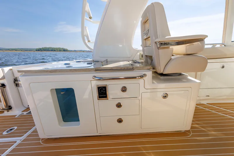 Slide: The Image of 2020 Boston Whaler 380 Realm interior with seating and storage, overlooking serene water. - 43