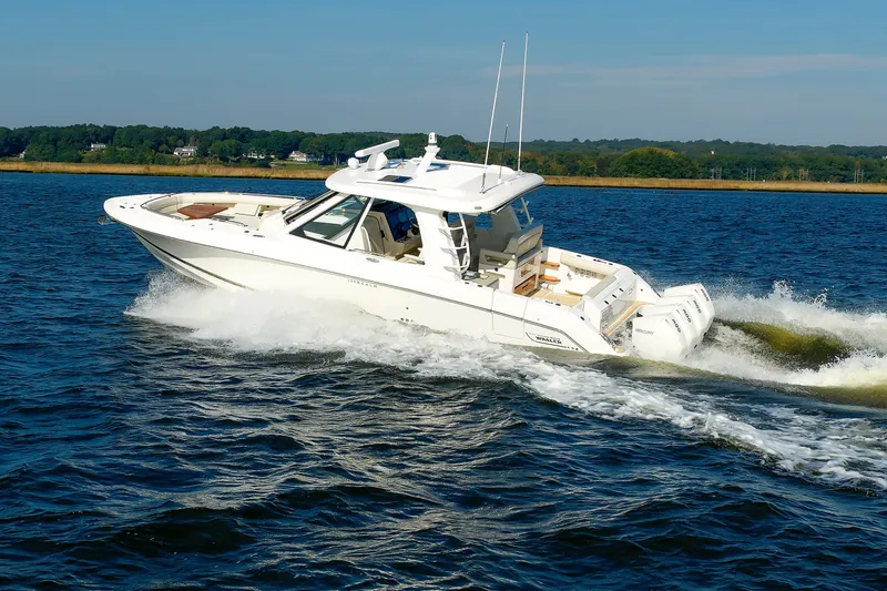 Slide: The Image of 2020 Boston Whaler 380 Realm cruising on a scenic lake under clear skies. - 28