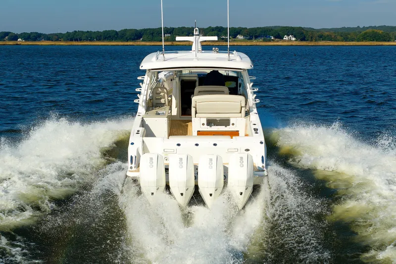Slide: The Image of 2020 Boston Whaler 380 Realm cruising on open water, rear view with powerful engines. - 26