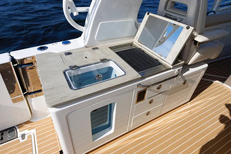 Slide: The Image of 2020 Boston Whaler 380 Realm boat kitchen area with sink and grill on deck. - 42